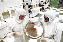 Dr. Michael Liehr (left) of SUNY Polytechnic Institute’s Colleges of Nanoscale Science and Engineering, and Bala Haran (right) of IBM Research, inspect a wafer comprised of 7 nm node test chips in a clean room in Albany, New York.